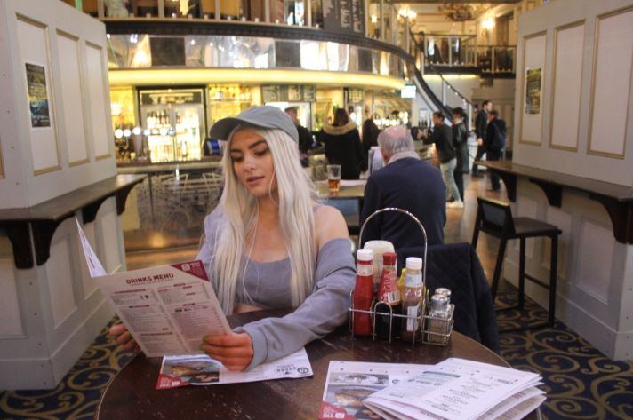 Image may contain: Restaurant, Cafe, Furniture, Couch, Woman, Girl, Female, Blonde, Bottle, Person, People, Human