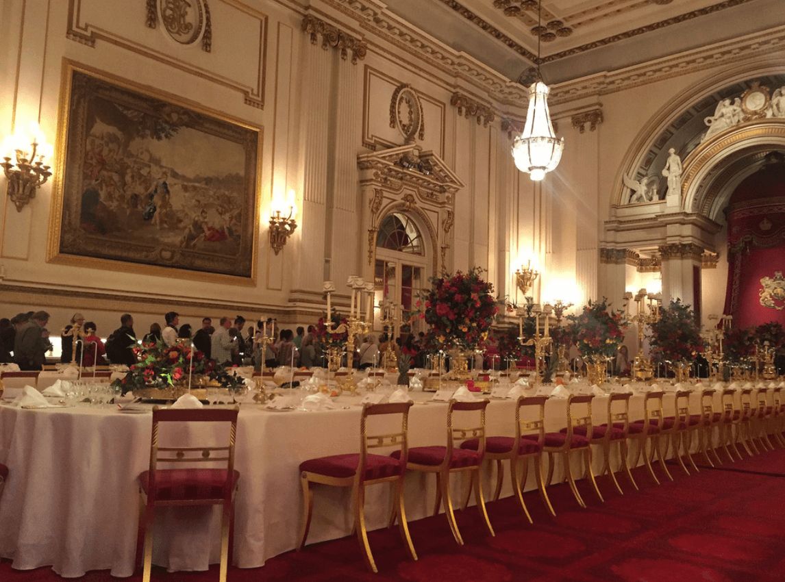 Image may contain: What does the Queen eat, meals, food, menu, pizza, takeaway, royal family, buckingham palace, the Queen, kitchen staff, Interior Design, Dining Room, Worship, Church, Cathedral, Building, Architecture, Altar, Waiting Room, Room, Reception Room, Reception, Indoors, Table, Furniture, Dining Table, Suitcase, Luggage