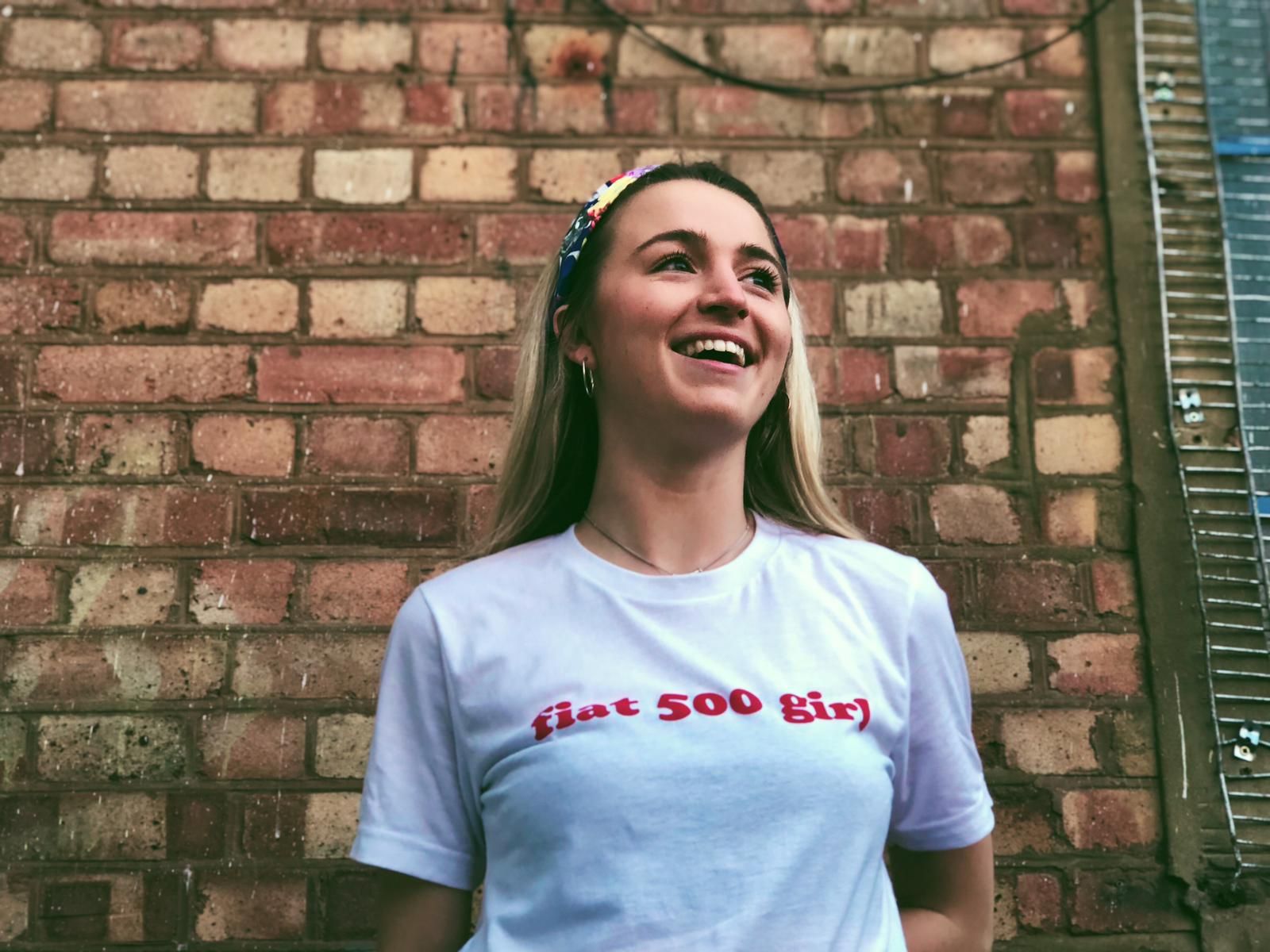 Image may contain: Female, T-Shirt, Face, Sleeve, Person, Human, Brick, Clothing, Apparel
