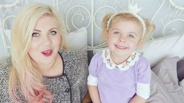 Image may contain: People, Couch, Furniture, Dress, Home Decor, Pillow, Cushion, Apparel, Clothing, Smile, Face, Woman, Female, Blonde, Child, Teen, Kid, Girl, Person, Human