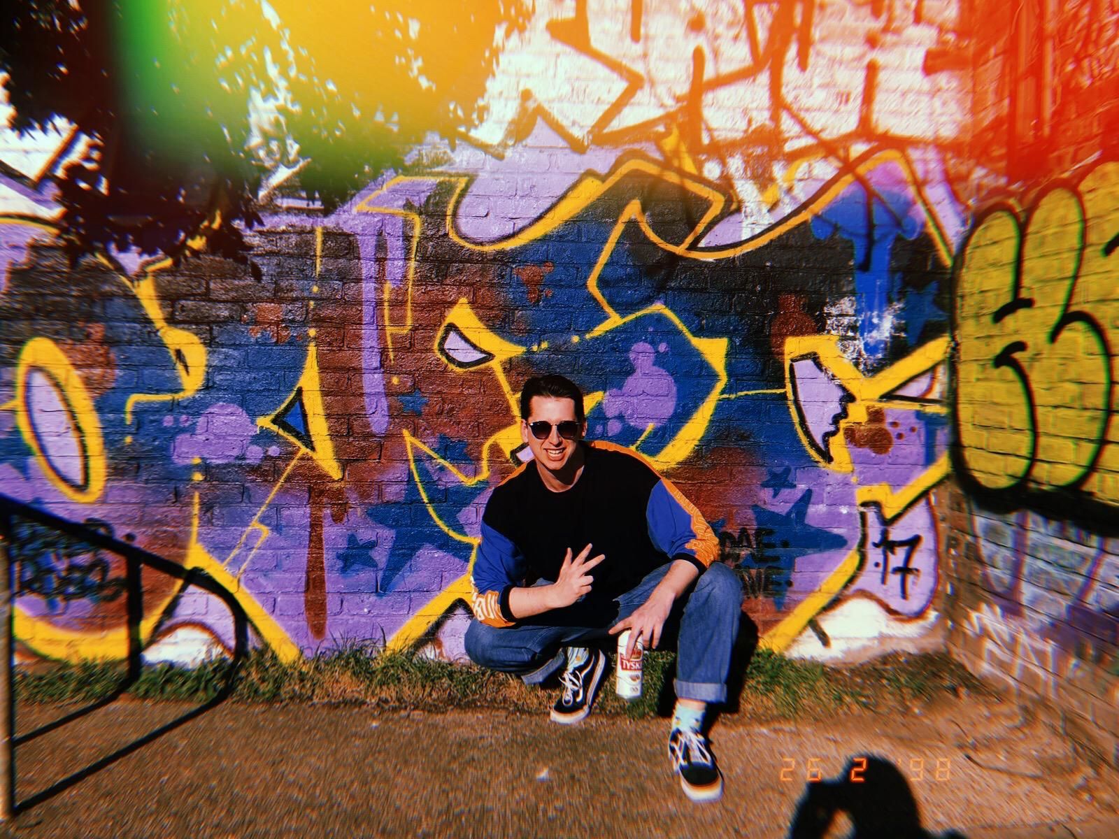 Image may contain: Wall, Clothing, Footwear, Apparel, Shoe, Accessories, Sunglasses, Accessory, Mural, Painting, Graffiti, Art, Human, Person