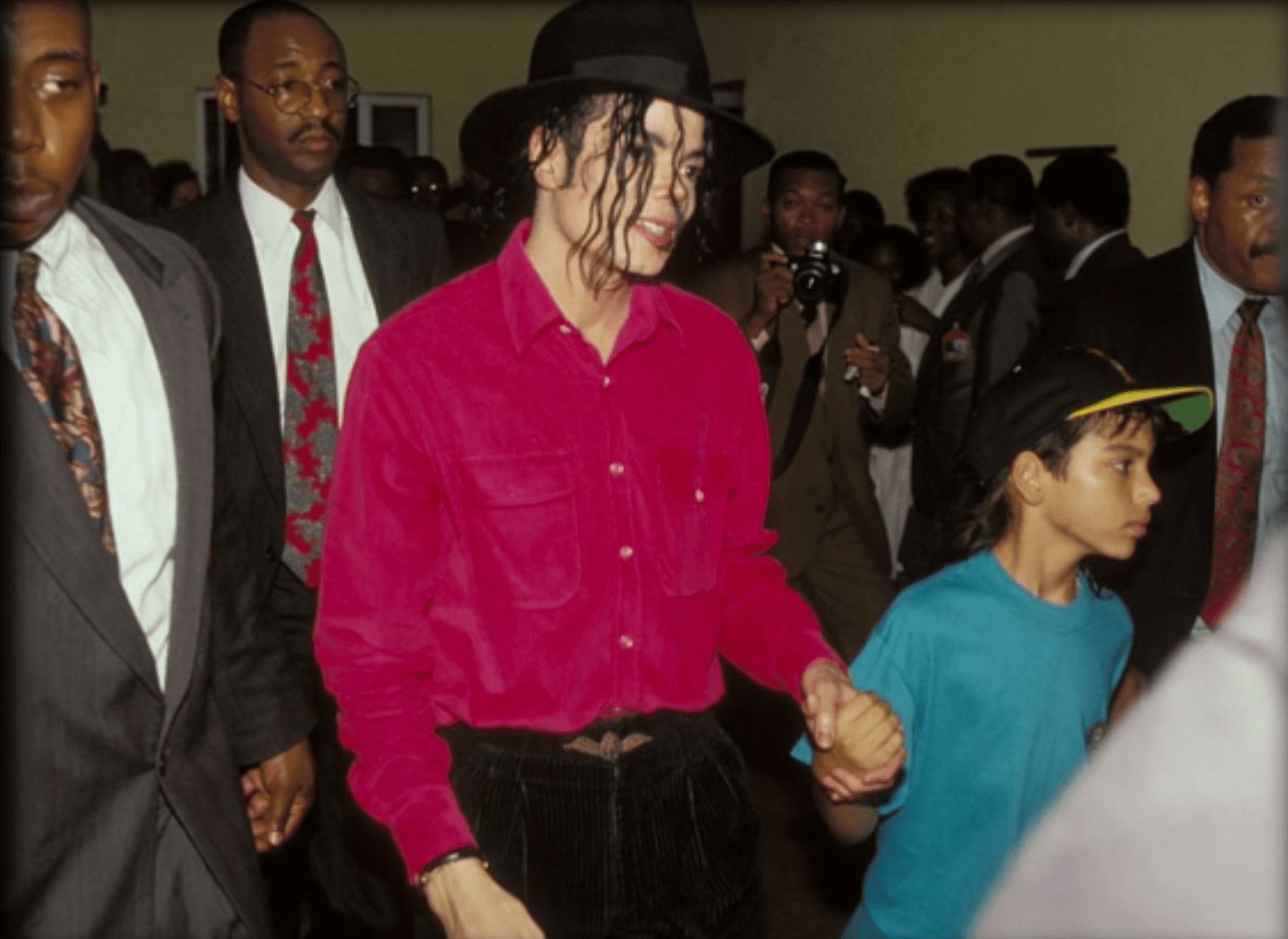 Image may contain: Michael Jackson and Macaulay Culkin, Michael Jackson, Brett Barnes, Leaving Neverland, Jacket, Crowd, Hat, Overcoat, Coat, Suit, Clothing, Apparel, Accessories, Tie, Accessory, Person, Human