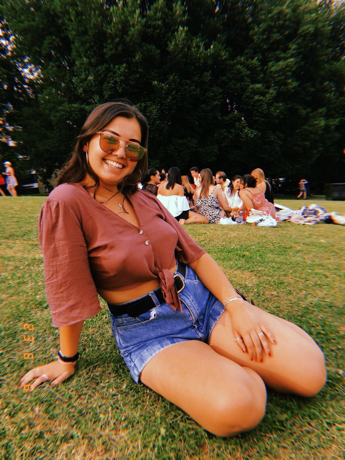 Image may contain: UK heatwave, Lawn, Sitting, Female, Shorts, Accessories, Sunglasses, Accessory, Human, Person, Plant, Grass, Clothing, Apparel