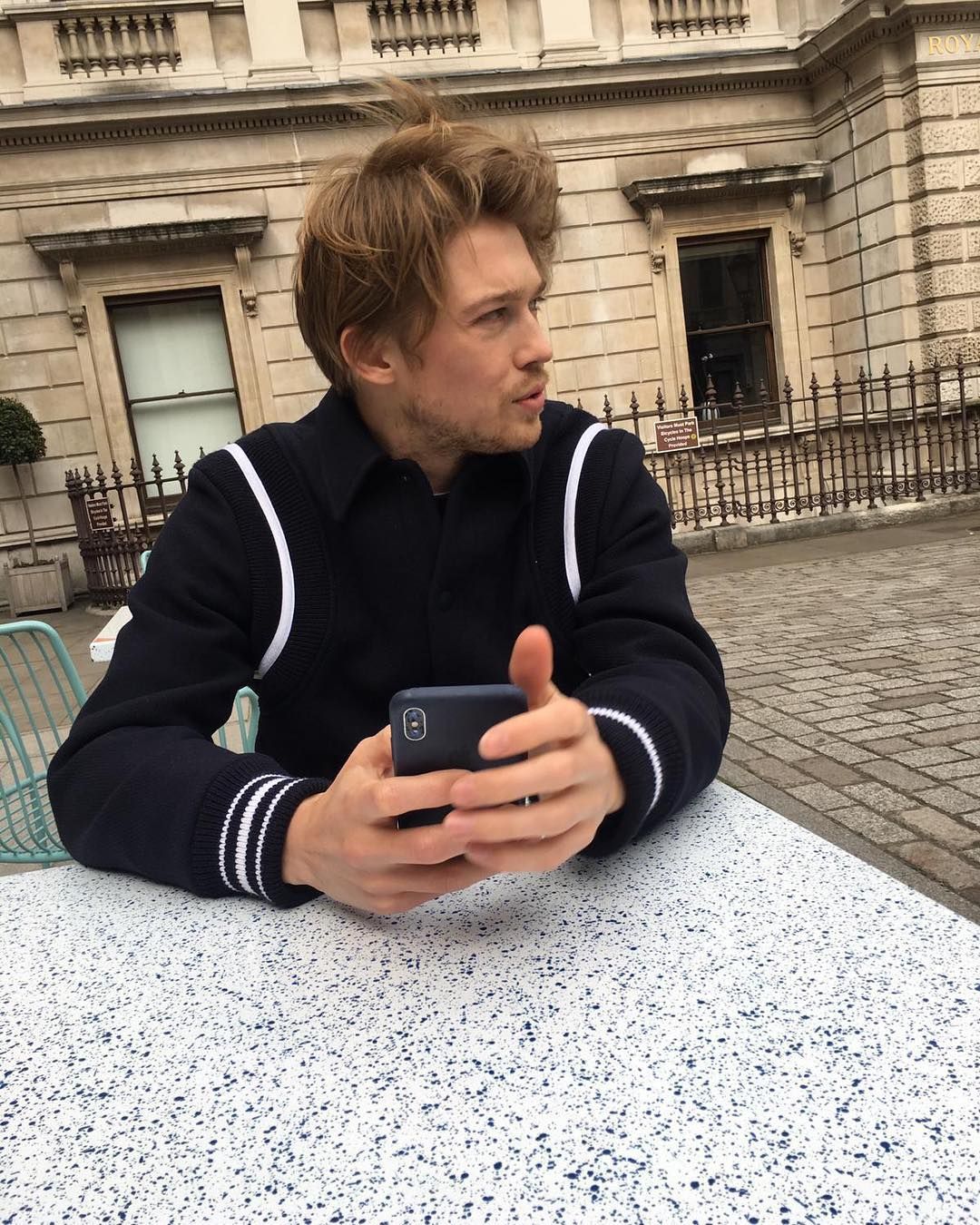 Image may contain: Who is Joe Alwyn, Joe Alwyn, Taylor Swift boyfriend, Taylor Swift, fiancee, engagement, boyfriend, Walkway, Path, Cell Phone, Mobile Phone, Phone, Electronics, Person, Human