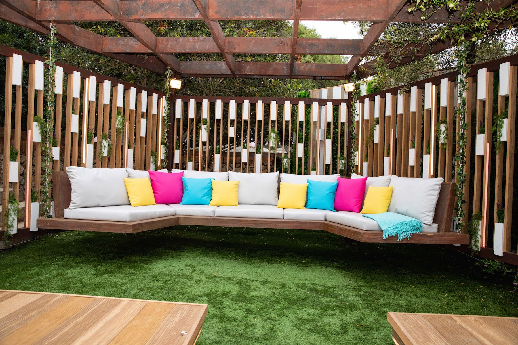 Image may contain: Love Island villa, 2019, location, Couch, Wood, Table, Outdoors, Pillow, Pergola, Furniture, Cushion, Patio, Porch