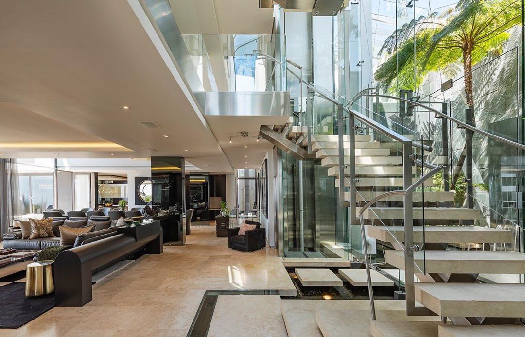 Image may contain: Moondance Villa, Made in Chelsea, Cape Town, South Africa, cost, book, MIC, price, location, Flooring, Table, Staircase, Furniture, Living Room, Housing, Building, Lobby, Indoors, Room