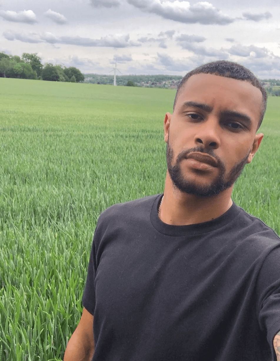 Image may contain: Casa Amor cast, Casa Amor, Love Island, Dennon Lewis, contestant, cast, Islander, new, boy, Instagram, age, job, Rural, Vegetation, Beard, Land, Man, Countryside, Grassland, Grass, Plant, Face, Field, Outdoors, Nature, Person, Human