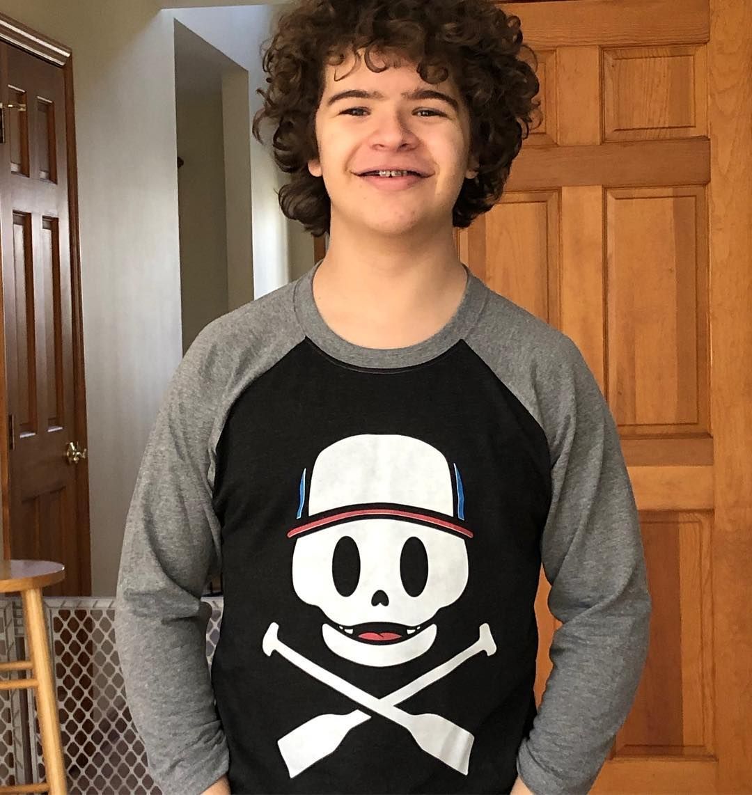 Image may contain:  Stranger Things cast ages, Stranger Things, 3, cast, age, old, birthday, Gaten Matarazzo, Dustin, Hair, Long Sleeve, Face, Sweatshirt, Hoodie, Sweater, Wood, Person, Human, Sleeve, Apparel, Clothing