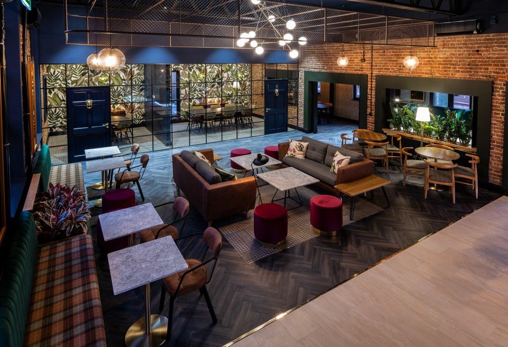 Image may contain: Hotel, Person, Human, Home Decor, Wood, Building, Table, Chair, Couch, Living Room, Interior Design, Furniture, Indoors, Room, Lobby