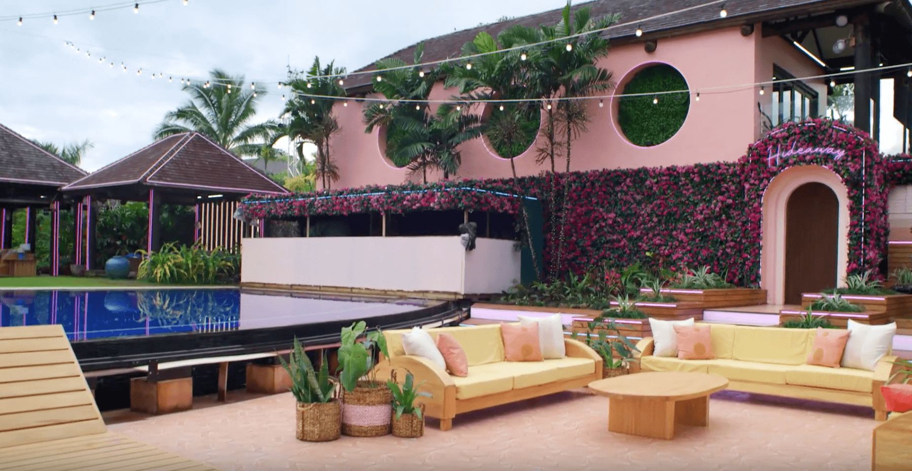 Image may contain: Love Island USA villa, Love Island USA, villa, Love Island, CBS, outside, decking, seating, lounge, palm trees, Fiji, Hideaway, Room, Patio, Indoors, Building, Hotel, Plant, Table, Furniture, Couch