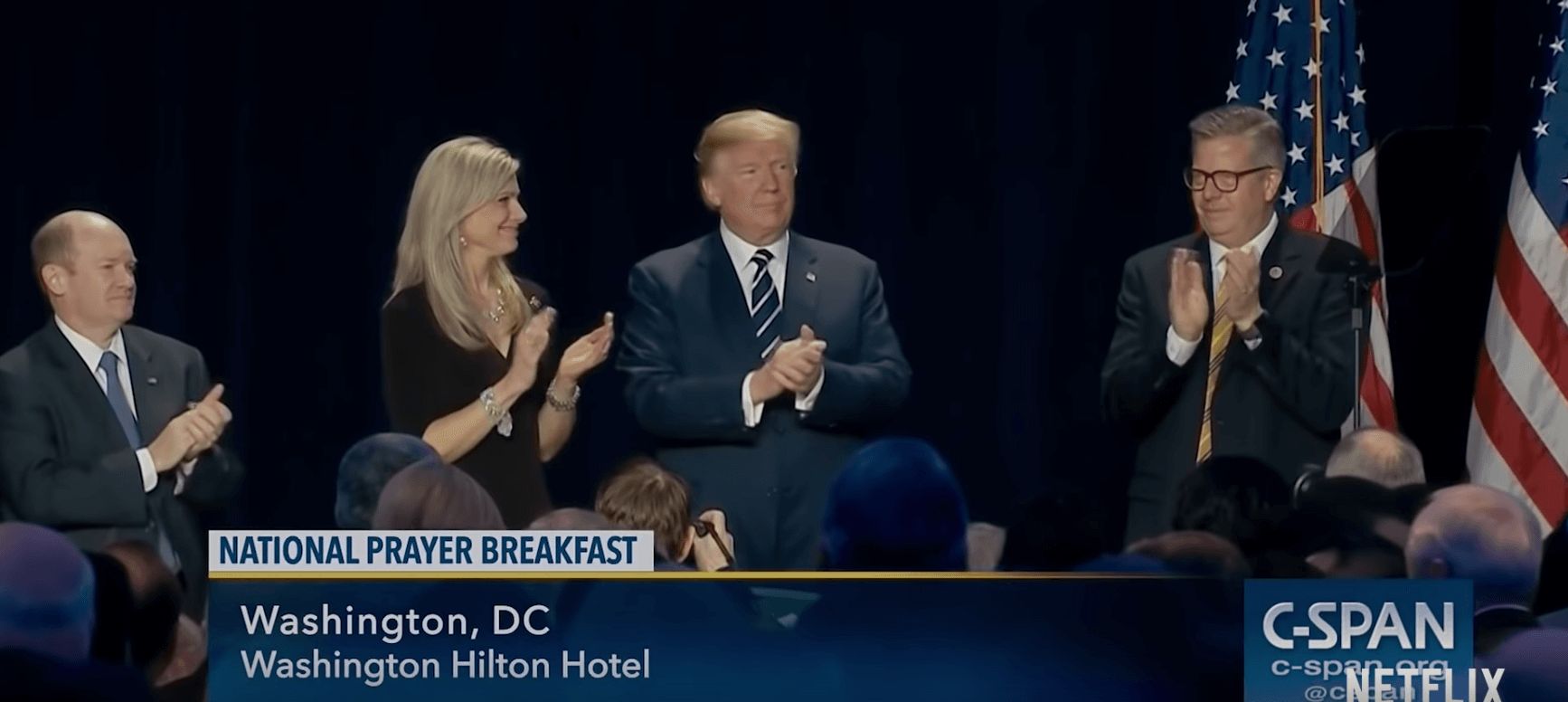 Image may contain: The Family, Netflix, National Prayer Breakfast, Donald Trump, president, The Fellowship, foundation, political, leaders, Christian group, real life, story, true crime, Doug Coe, book, documentary, reddit, review, trailer, cast, plot, limited series, Washington DC, conspiracy, theories, Accessory, Tie, Accessories, Debate, Symbol, Flag, Coat, Overcoat, Clothing, Suit, Apparel, Speech, Crowd, Audience, Person, Human