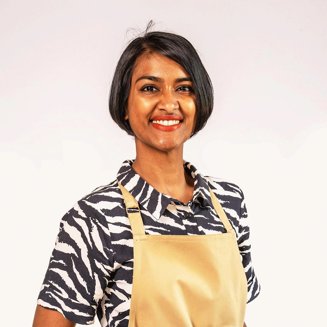 Image may contain: Great British Bake Off 2019, Priya O'Shea, Priya, cast, contestants, lineup, Instagram, GBBO, Bake Off, 2019, start date, Channel 4, Female, Apron, Face, Sleeve, Apparel, Clothing, Human, Person