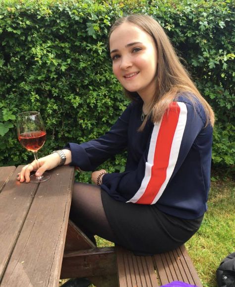 Image may contain: Pants, Red Wine, Kid, Girl, Child, Teen, Blonde, Wine Glass, Nature, Yard, Vegetation, Plant, Apparel, Clothing, Outdoors, Woman, Glass, Wine, Drink, Beverage, Alcohol, Human, Person, Female