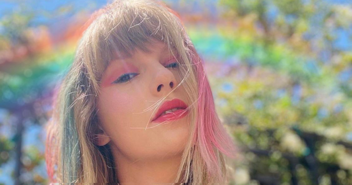 Taylor Swift selfie with rainbow behind her