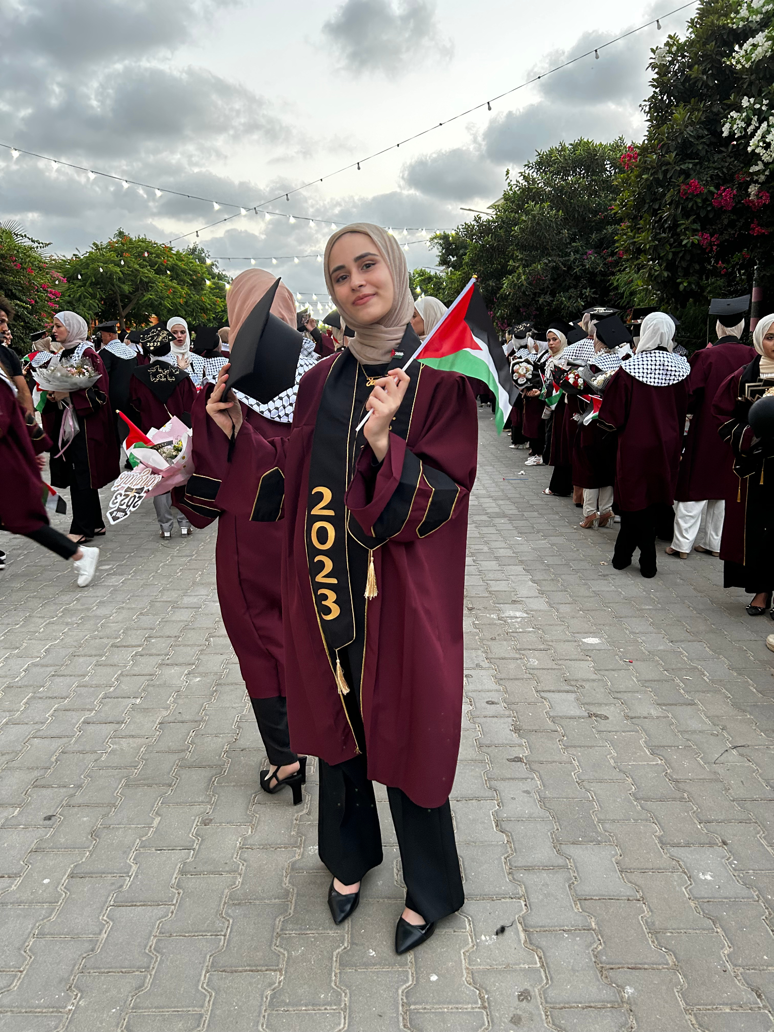 Yara waving a Palestinian flag before her evacuation to commence studies as a Sheffield student