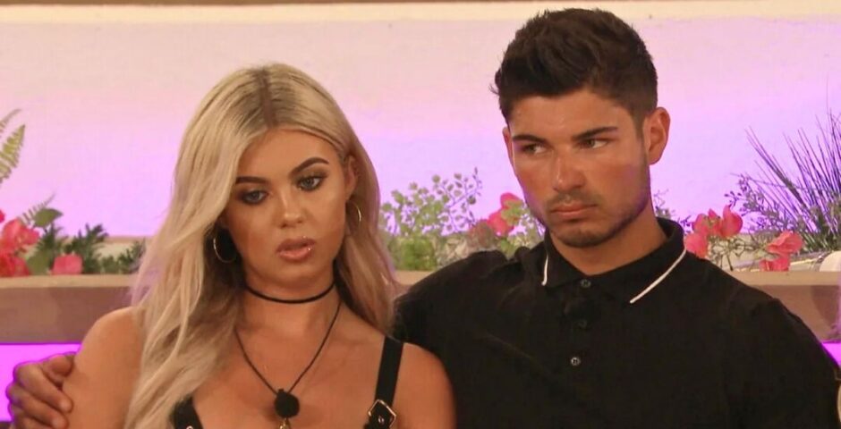 Anton and Belle looking super cheerful at the firepit love island recoupling