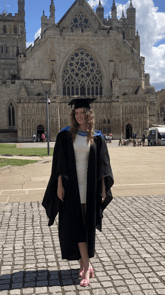 A grad smiling away by Exeter Cathedral uni of exeter